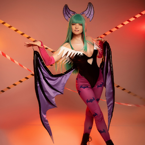 Morrigan Aensland strikes a playful pose, her signature bat wings framing her in a dynamic stance. The vivid green hair and bold black bodysuit adorned with purple bat patterns capture her dark allure, while the warm orange lighting adds an atmospheric glow. Surrounded by caution tape, this portrayal of the iconic succubus from Darkstalkers emphasizes her mischievous charm and captivating confidence.