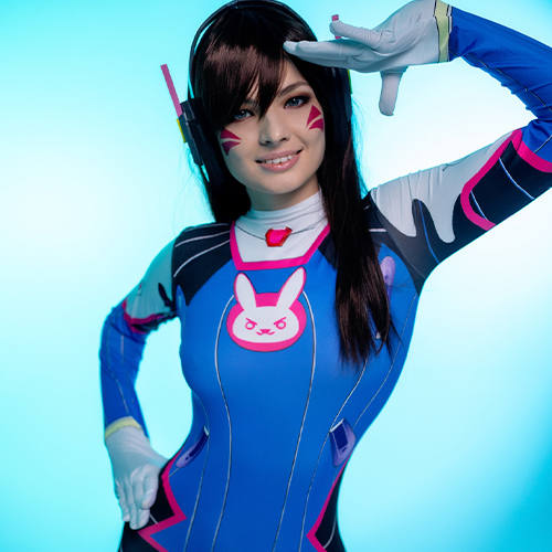 D.Va Overwatch cosplay – crisp blue background, salute pose, bunny emblem
