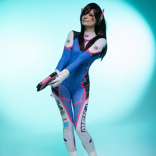 This captivating D.Va cosplay highlights the hero’s energetic and playful nature from Overwatch. With a turquoise backdrop amplifying the character's futuristic vibe, the pink and blue bodysuit stands out, showcasing its detailed decals and iconic design. The pose, featuring D.Va’s signature pink light gun, perfectly encapsulates the essence of this popular mech pilot and gamer icon.