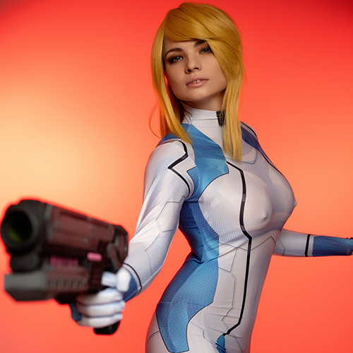 This captivating Zero Suit Samus cosplay embodies the spirit of the legendary Metroid series. The sleek blue suit, accentuated by sharp detailing and the iconic paralyzer pistol, perfectly mirrors the aesthetics of the game. The intense red background highlights the dynamic pose, capturing the interstellar heroine in action. This portrayal is a tribute to the strength and agility of Samus Aran, making it a must-see for fans of Nintendo’s iconic bounty hunter.