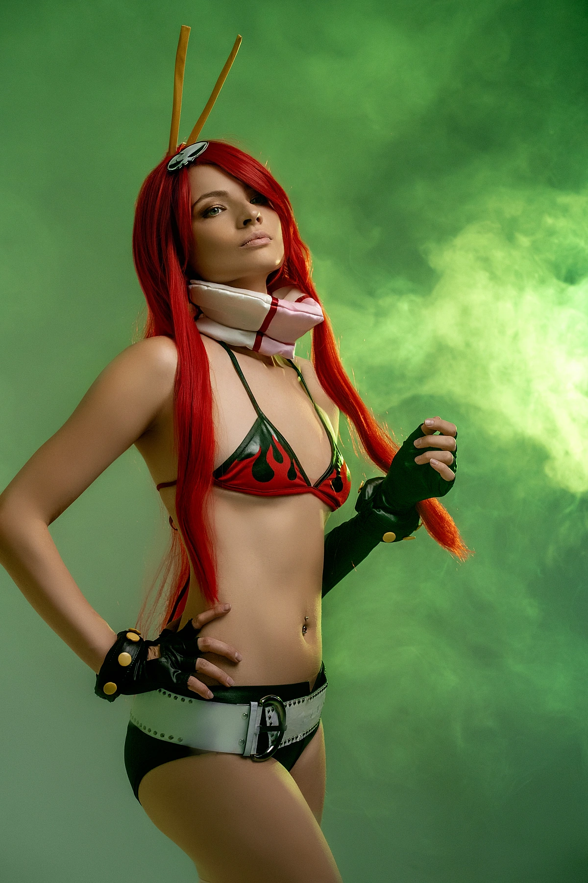 Yoko Littner cosplay standing pin-up pose, green smoke studio, flame bikini top, wide belt, black gloves, hand on hip, neon anime lighting