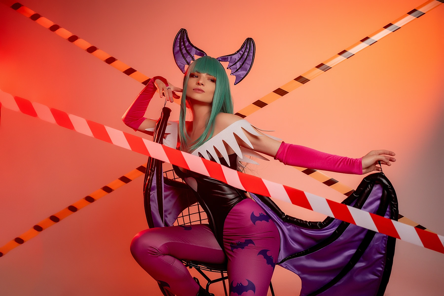 Morrigan Aensland cosplay behind crossed warning tape, seated pose, succubus wings, warm studio lighting, glossy bodysuit