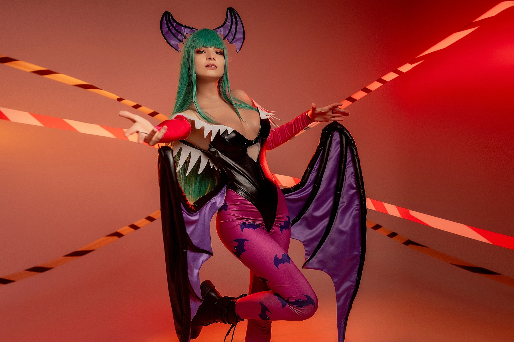 Morrigan Aensland Darkstalkers cosplay reaching forward pose, warm red studio lighting, succubus wings, glossy bodysuit