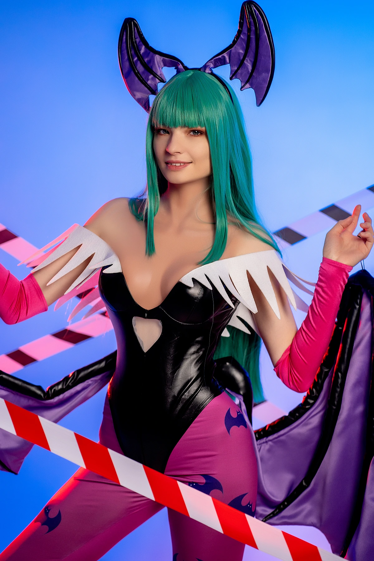 Morrigan Aensland cosplay neon close portrait, blue studio glow, glossy bodysuit, green hair, succubus wing fabric