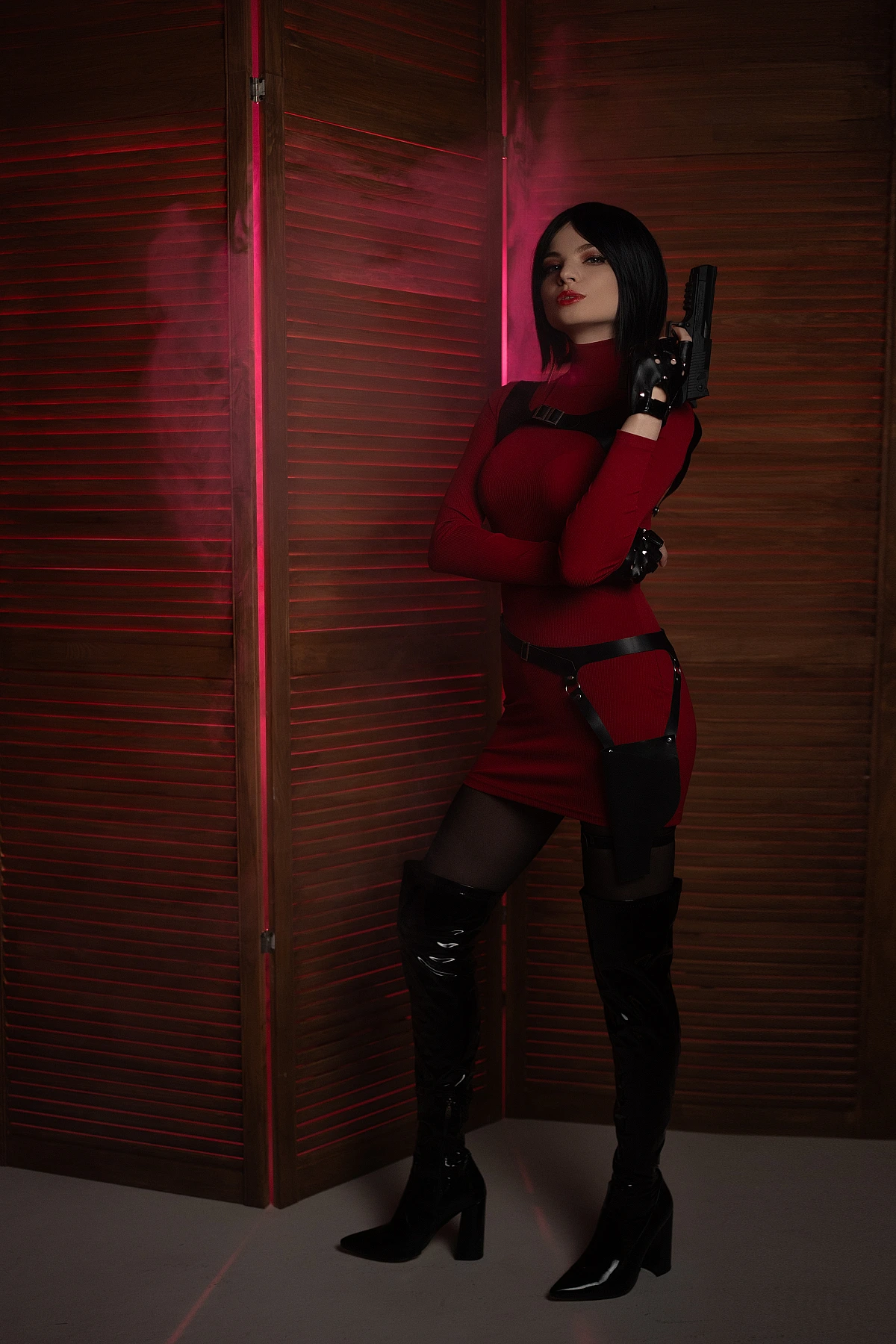 Ada Wong cosplay portrait red bodycon dress pistol pose black gloves thigh-high boots warm lighting wooden panels