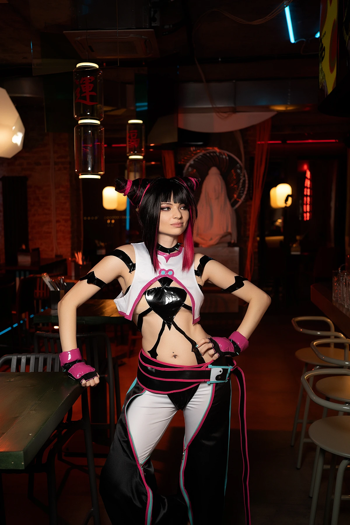 Juri Han cosplay standing centered in neon bar with strong symmetrical pose, hanging lights and warm ambient lighting