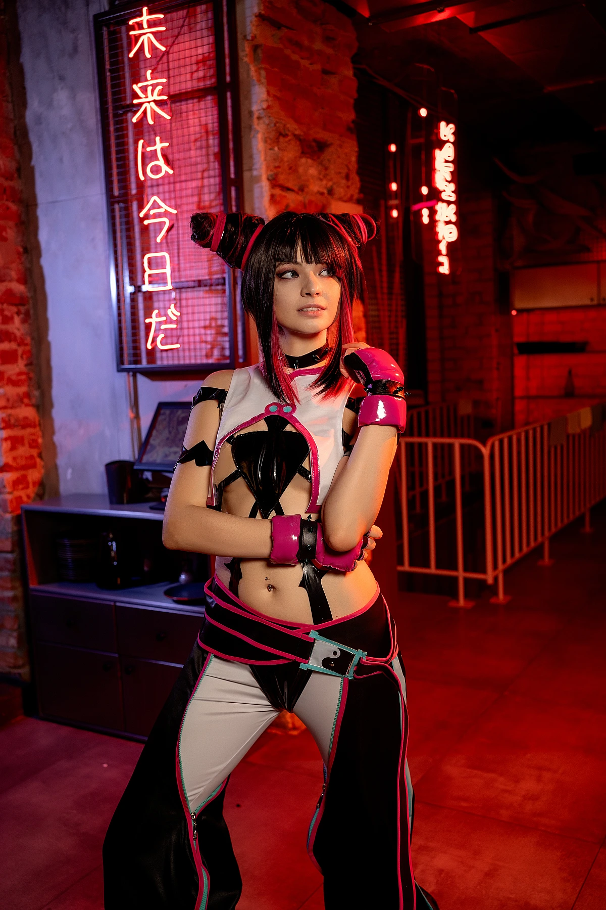 Juri Han cosplay with crossed arms under neon signs, calm confident side glance, warm red brick lighting, closing gallery portrait