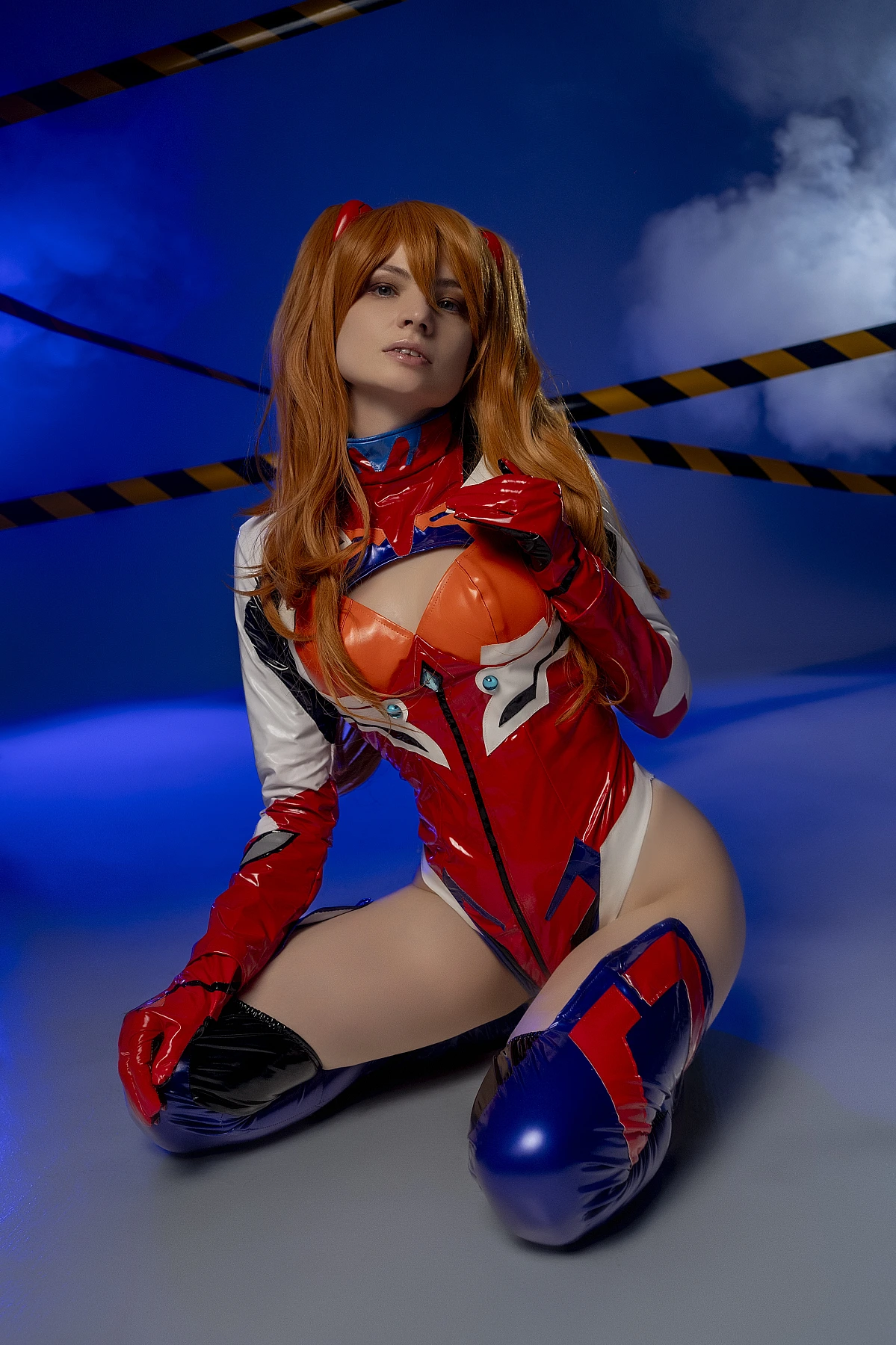 Asuka kneeling pose cosplay in latex plugsuit with skin sheen and blue lighting