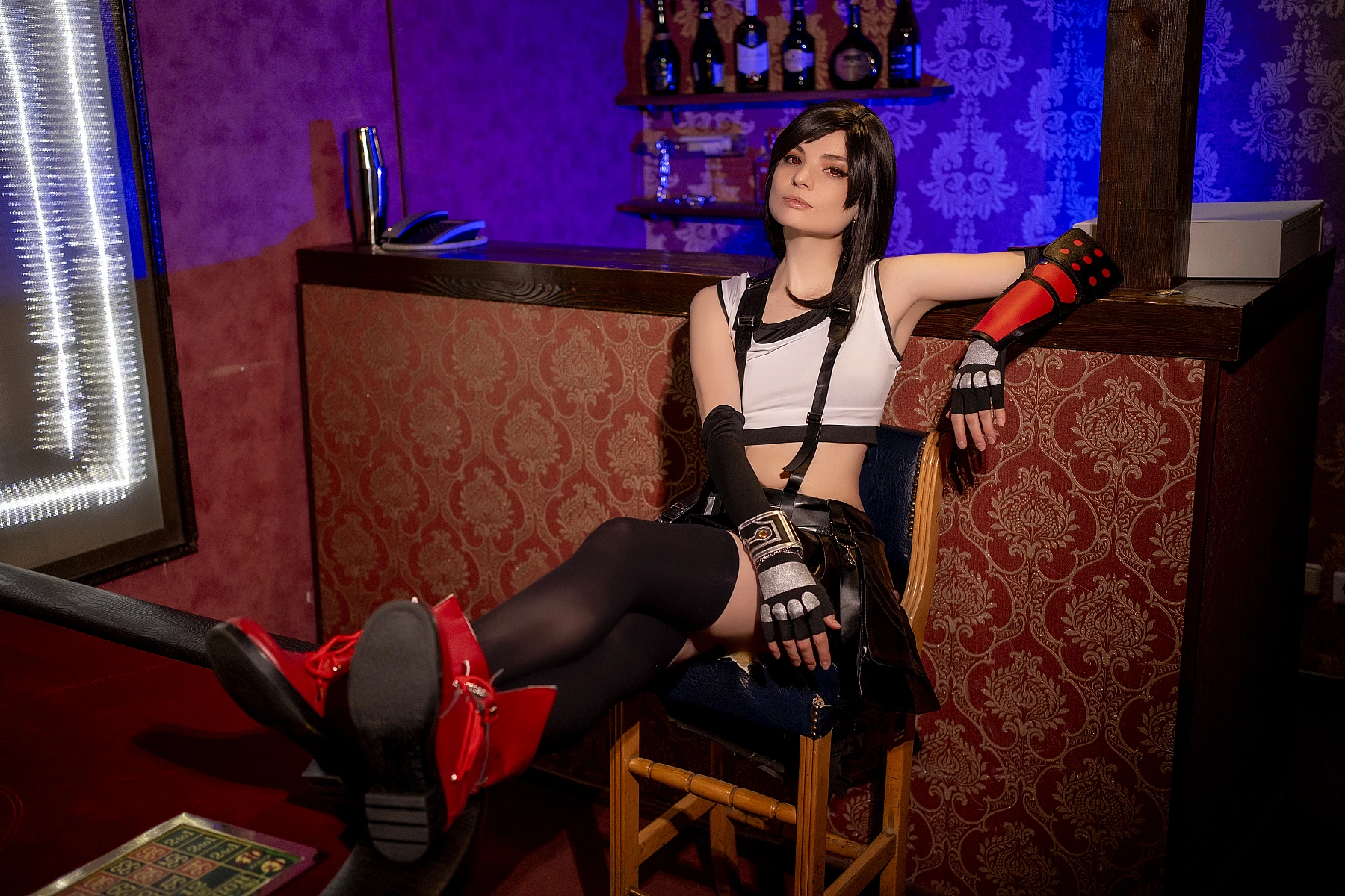 Tifa Lockhart cosplay 7th Heaven bar lounge, reclined chair pose, muscular legs, FF7 costume, thigh-high stockings, red boots, moody bar lighting