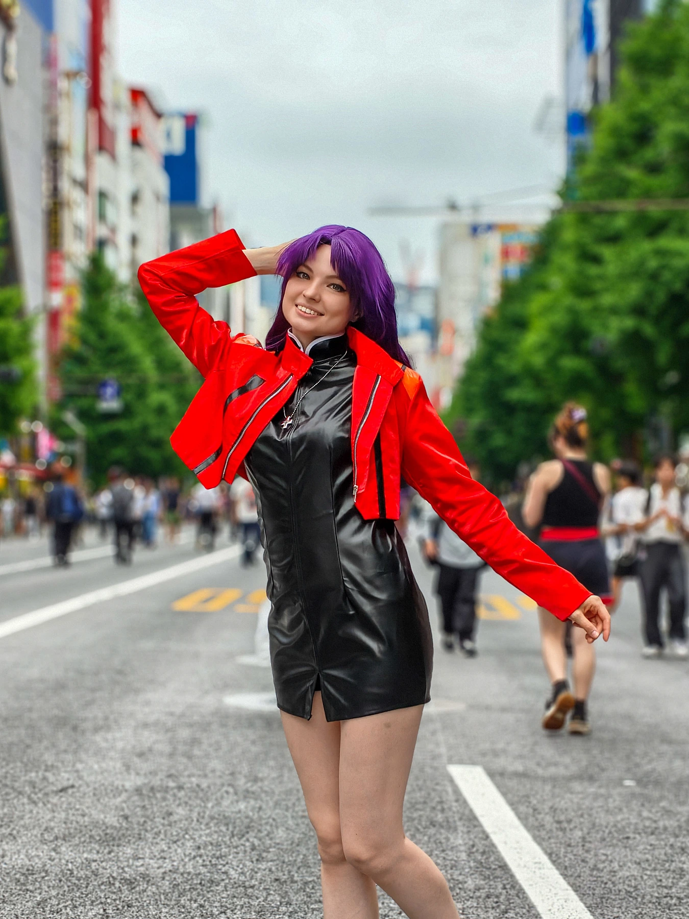 Misato Katsuragi cosplay smiling on a Tokyo street in a red jacket, black dress and long purple hair