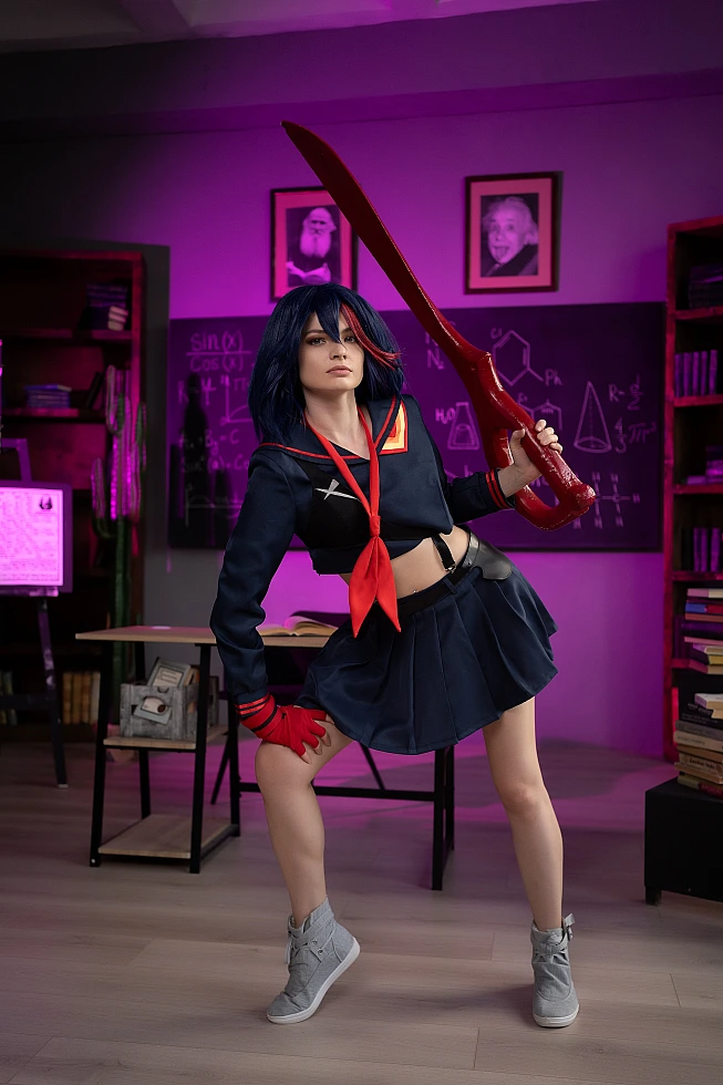 Ryuko Matoi cosplay leaning on classroom desk with scissor blade in purple neon light