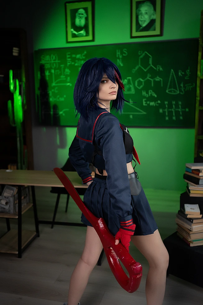 Ryuko Matoi cosplay side profile with blade held low in emerald green lighting