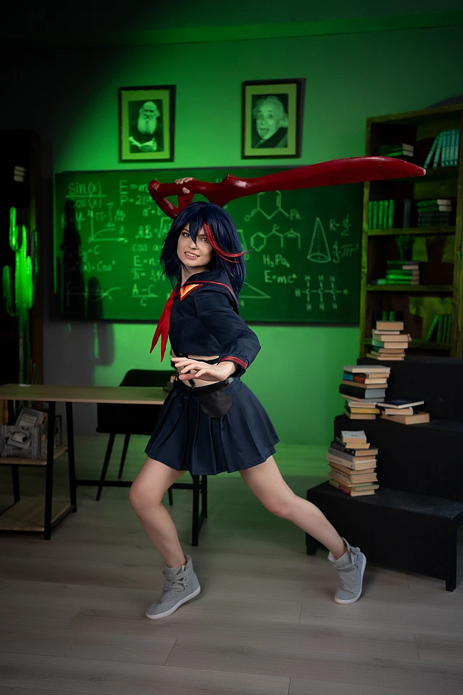 Ryuko Matoi cosplay in athletic stance with scissor blade arcing overhead in green light