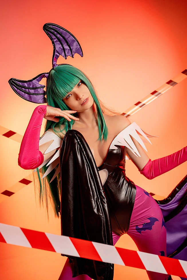 Morrigan Aensland cosplay close-up portrait, tilted head, warm orange studio lighting, glossy bodysuit, green hair