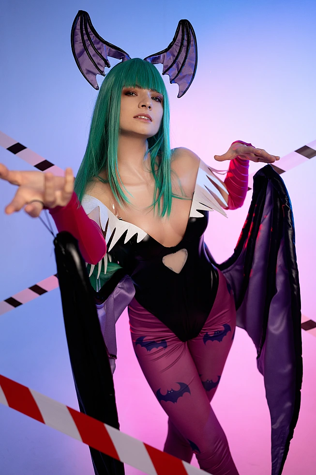 Morrigan Aensland cosplay close portrait, forward hands, neon blue-pink studio lighting, glossy bodysuit, succubus wings