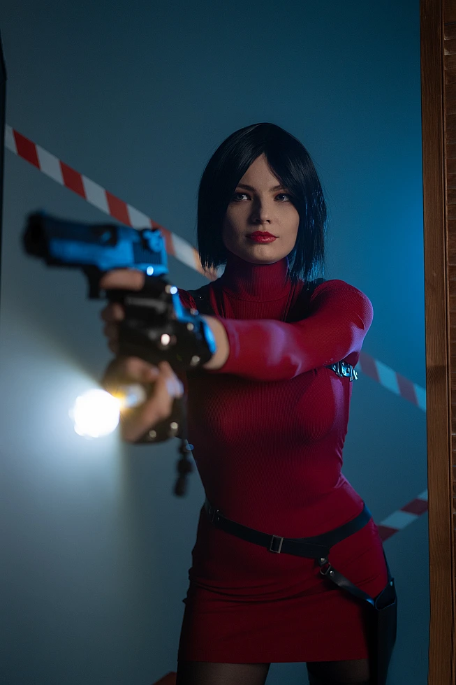 Ada Wong cosplay action pose pistol aimed forward red dress harness straps blue backlight intense gaze