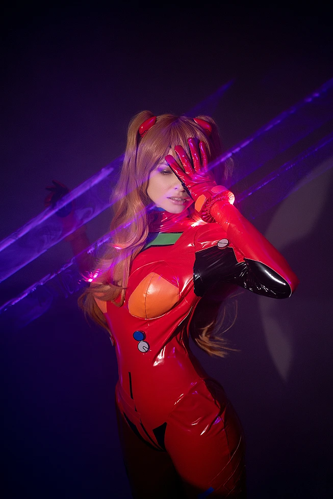 Full body Asuka Langley cosplay in shiny latex-style red plugsuit with matching gloves, standing pose under neon studio lighting with long orange hair