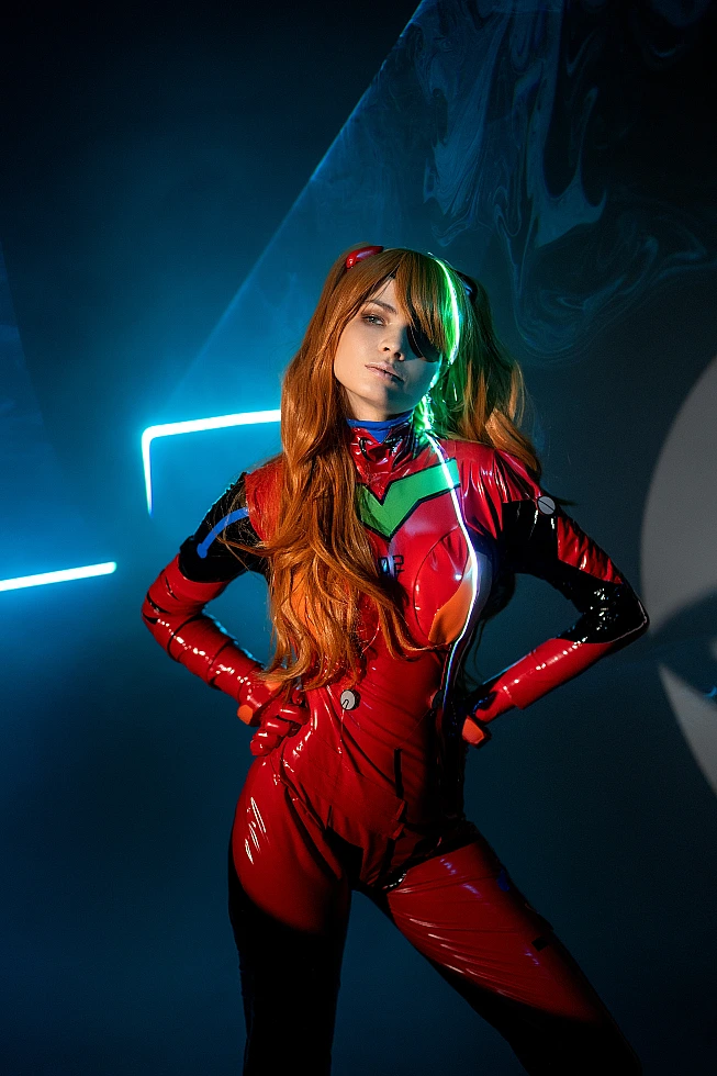 Close-up Asuka Langley cosplay portrait featuring glossy red plugsuit with neon key lighting, orange hair and dramatic studio shadows
