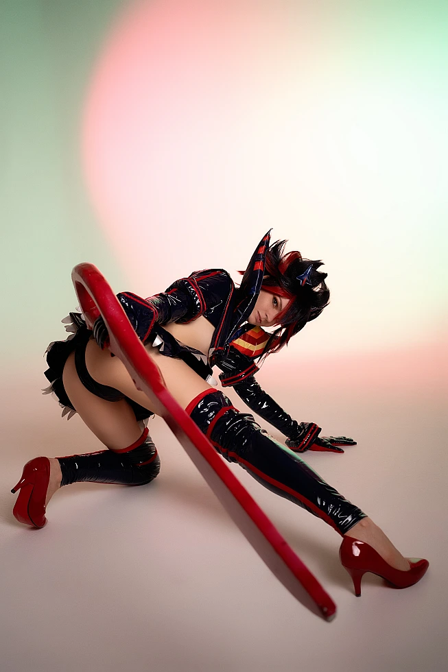 Ryuko Matoi cosplay floor level stretch pose scissor blade foreground soft pastel studio gradient Kill la Kill cinematic