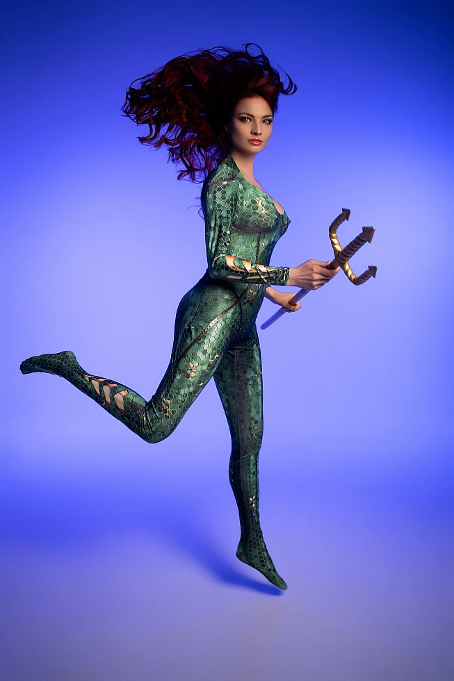Mera cosplay mid-jump action shot holding golden trident with dramatic hair movement