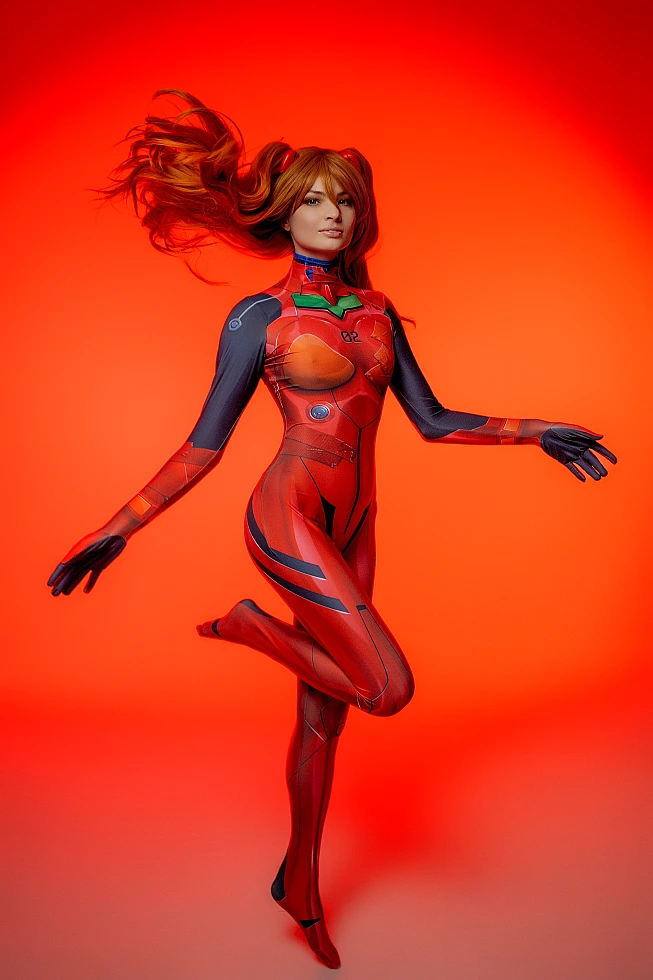 Asuka Langley cosplay in red plugsuit on neon red background with flowing hair