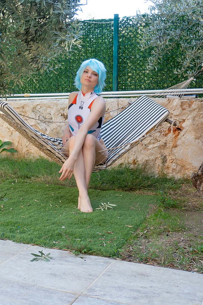 Rei Ayanami cosplay seated hammock crossed legs introspective white plugsuit soft light Evangelion character study
