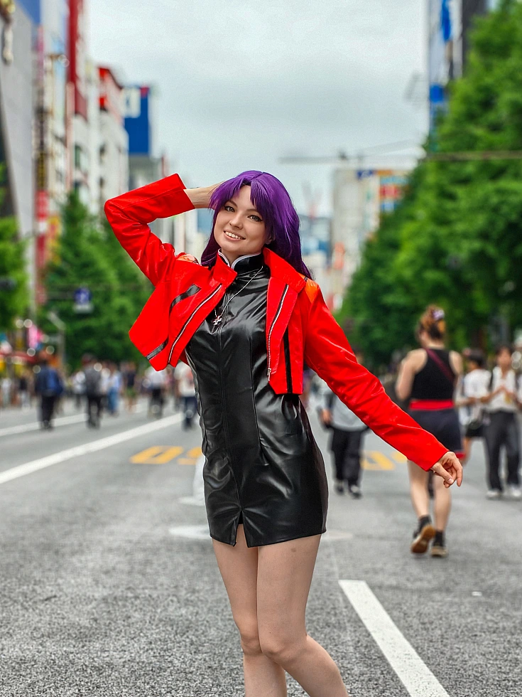 Misato Katsuragi cosplay smiling on a Tokyo street in a red jacket, black dress and long purple hair