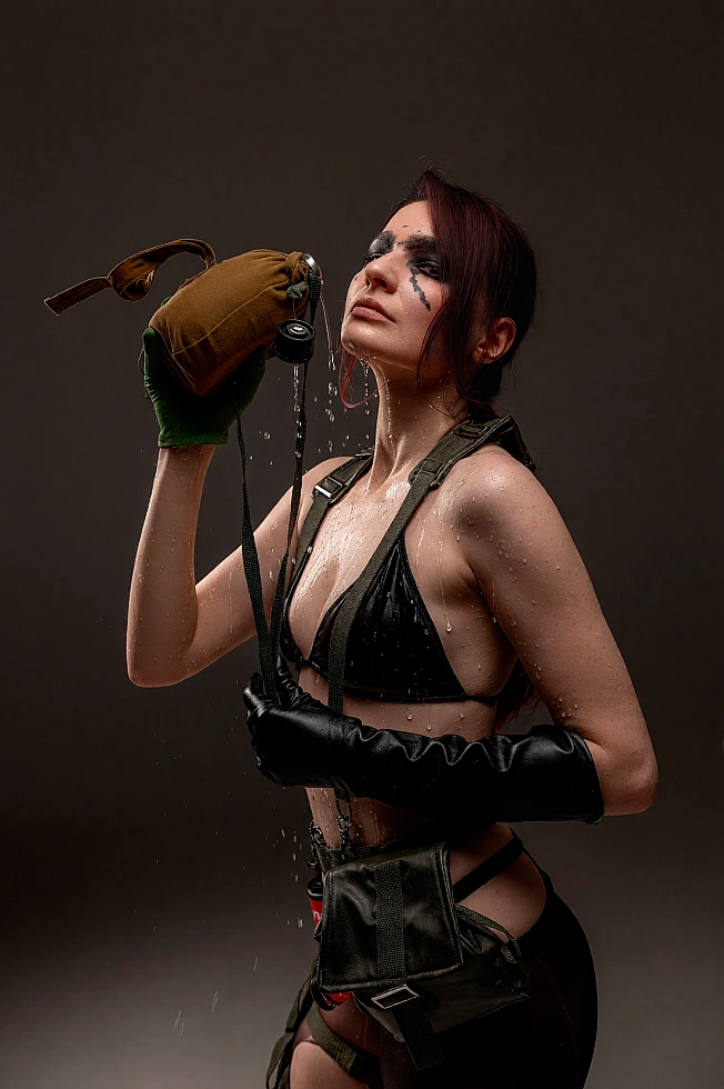 Quiet cosplay portrait with tactical gear, face paint and water pouring from a canteen in a dark studio setting