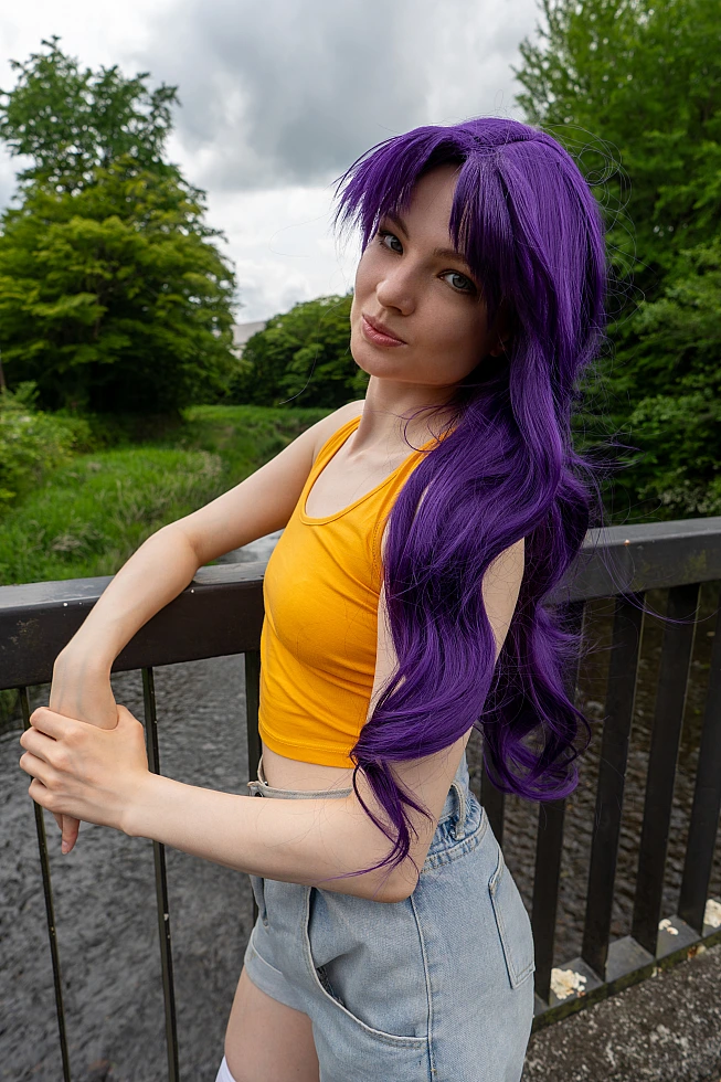 Misato Katsuragi casual cosplay leaning by a riverside bridge with long purple hair, yellow top and denim shorts