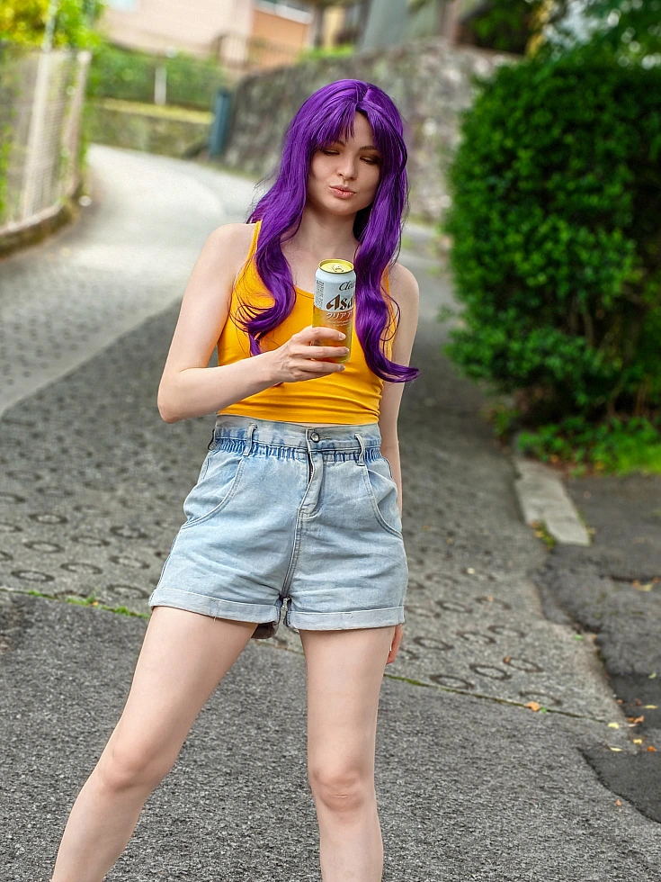 Misato Katsuragi casual cosplay holding a drink can on a quiet street with purple hair and yellow top